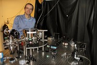 Andre Geraci bij een apparaat dat lijkt op de gravitatiegolf-detector die hij heeft voorgesteld